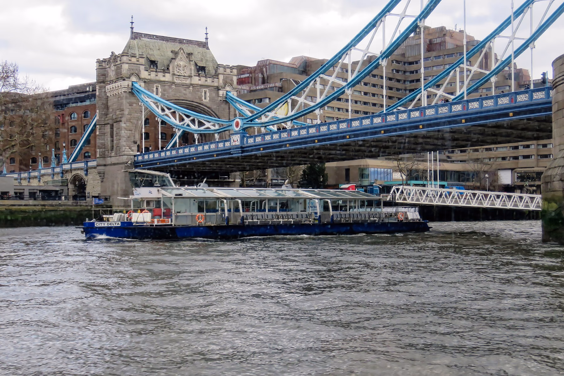 A Thames sightseeing boat passing beneath Tower Bridge